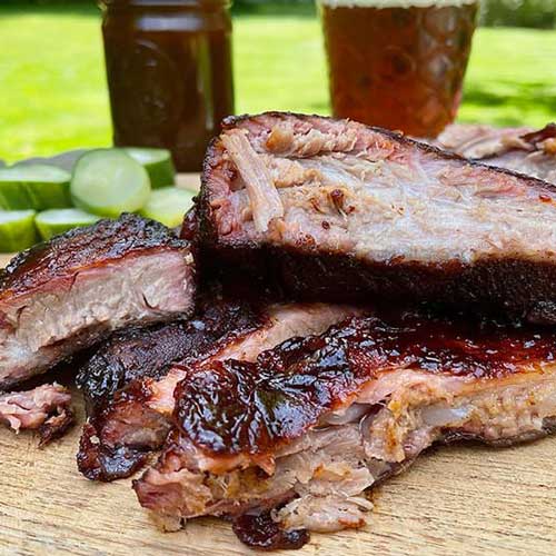 Freshly cooked barbeque ribs on a wooden cutting board from 5B Barbeque and Brews