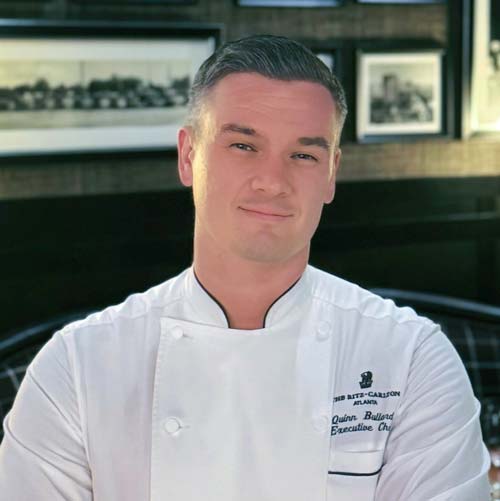 Portrait of Ritz-Carlton Atlanta Executive Chef Quinn Bullard, smiling at the camera.