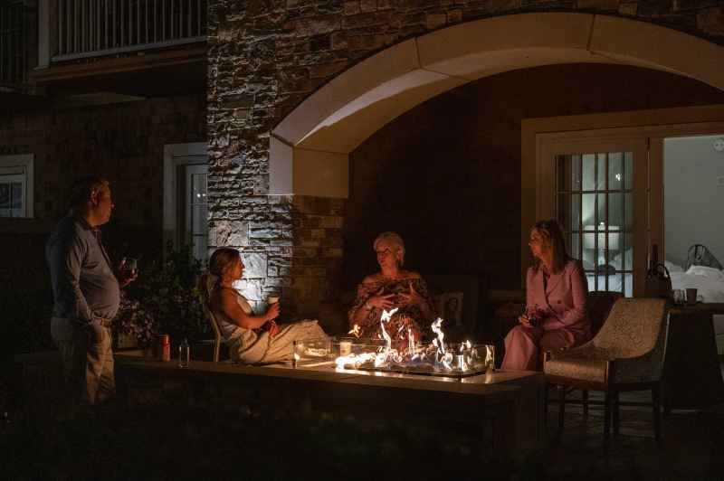 A group of festival attendees siting around a camp fire enjoying the spring festival evening at the grand tasting.